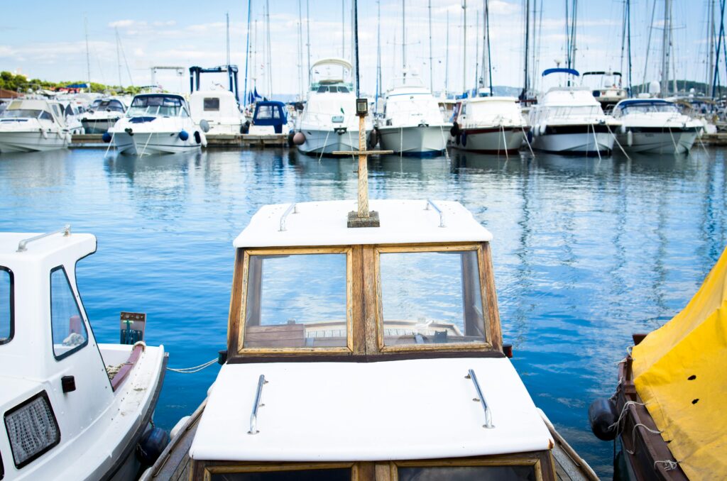 A picturesque marina with boats and yachts reflecting beautifully in the calm blue waters.
